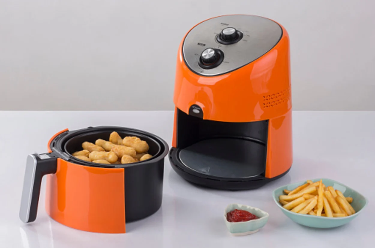 An image showing an air fryer with an orange body