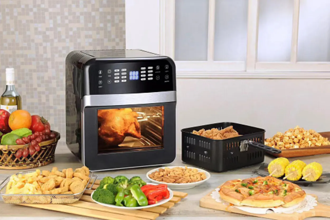 An air fryer along with several foods placed in front of it.