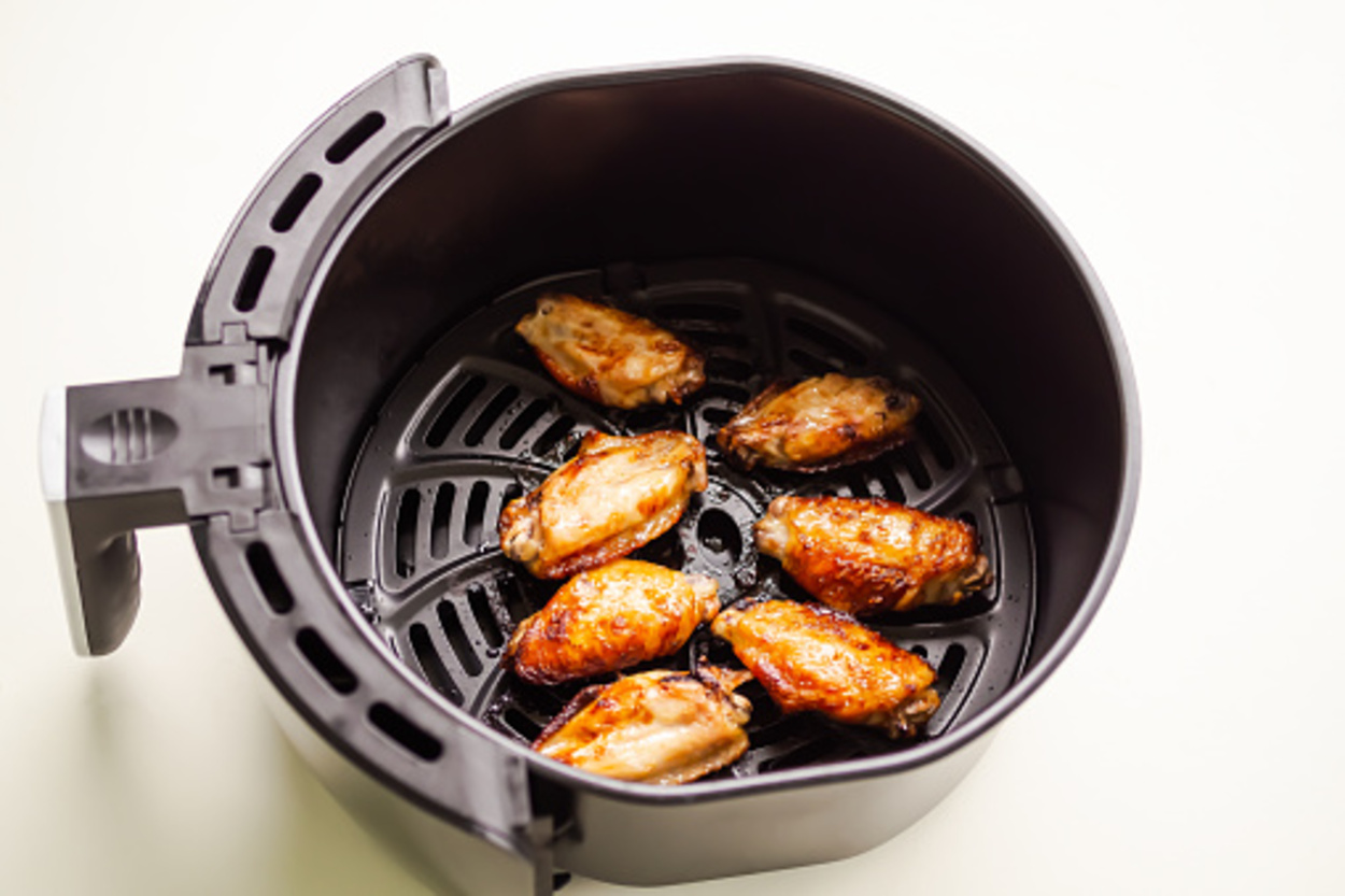 Cooked chicken wings in an air fryer basket