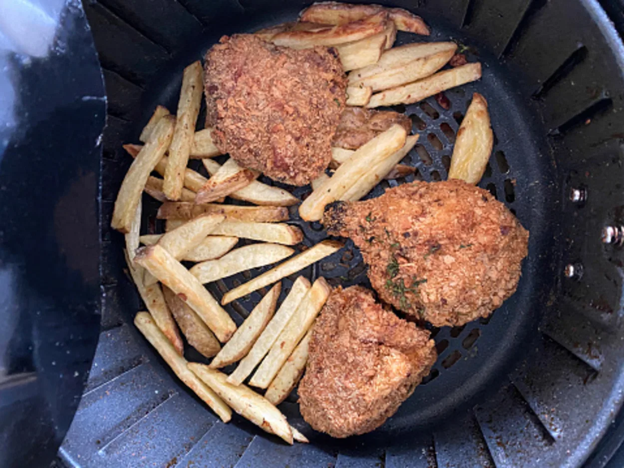 A image showing fries along with boast in an air fryer