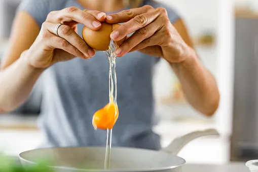 a woman cracking aa egg