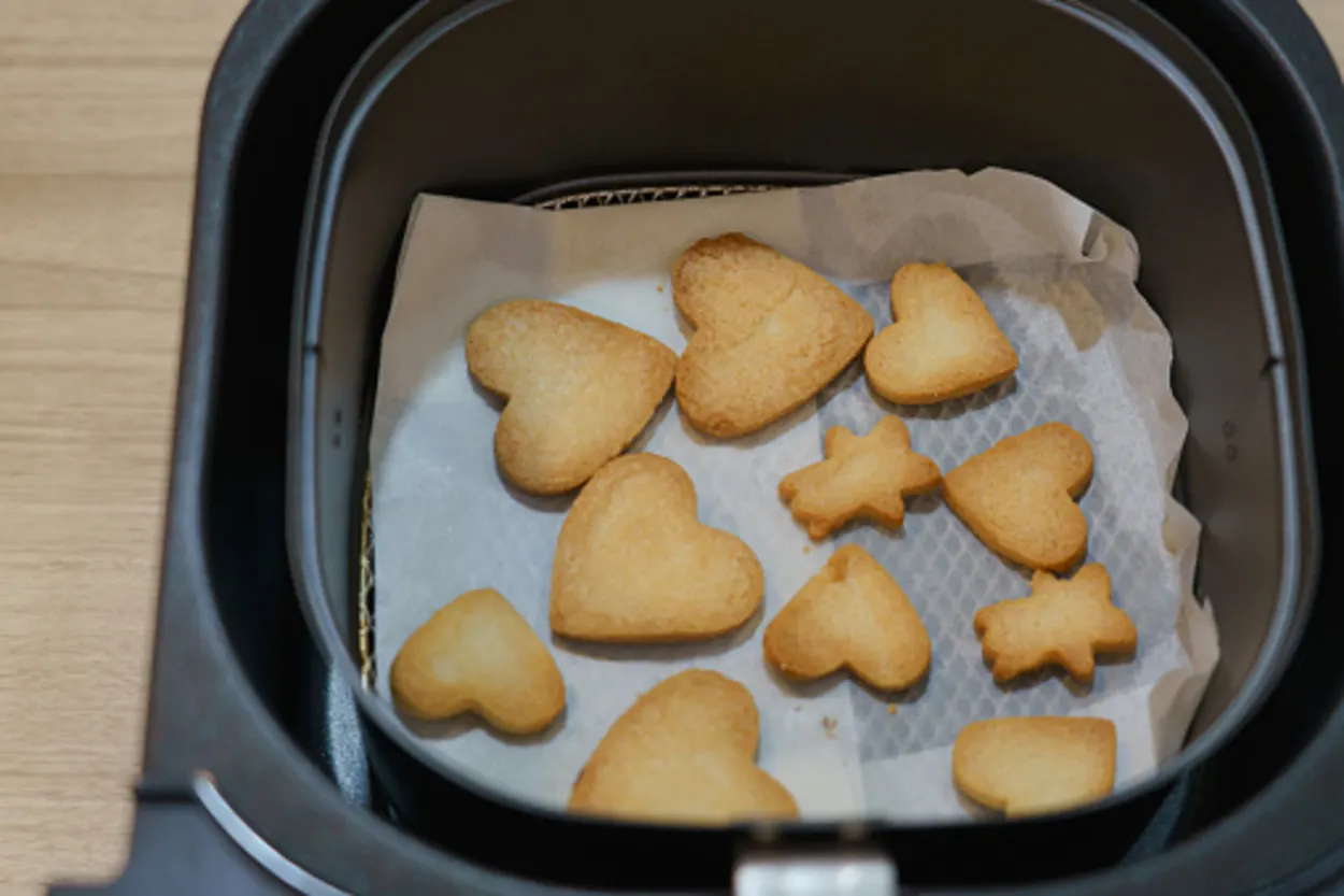 multiple-shaped cookies in an air fryer basket