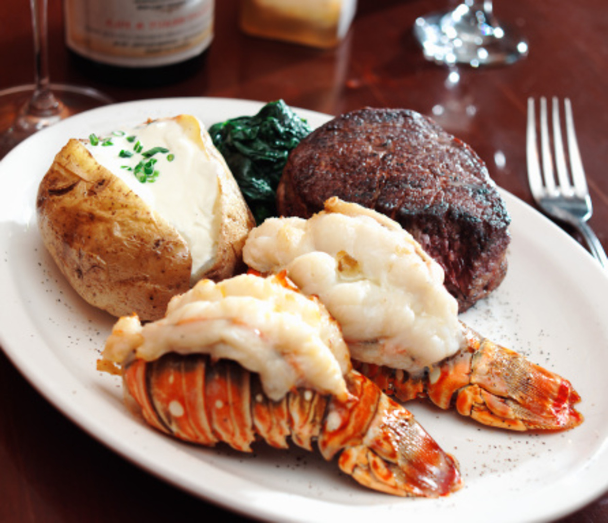 Lobster tails with baked potato and spinach.
