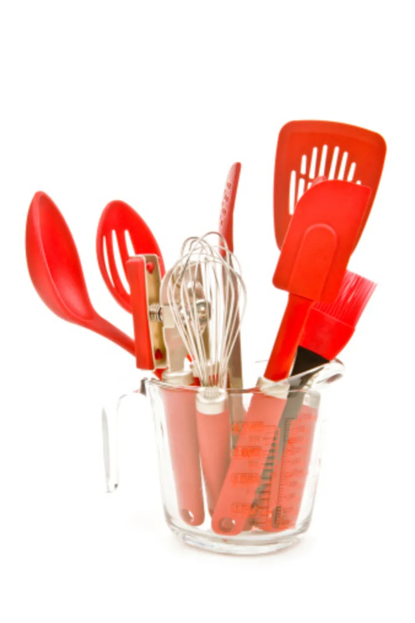 Silicon tong, spatula and whisk in a glass container