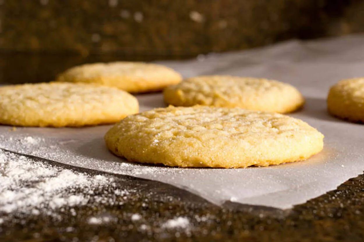 Sprinkling icing sugar on cookies