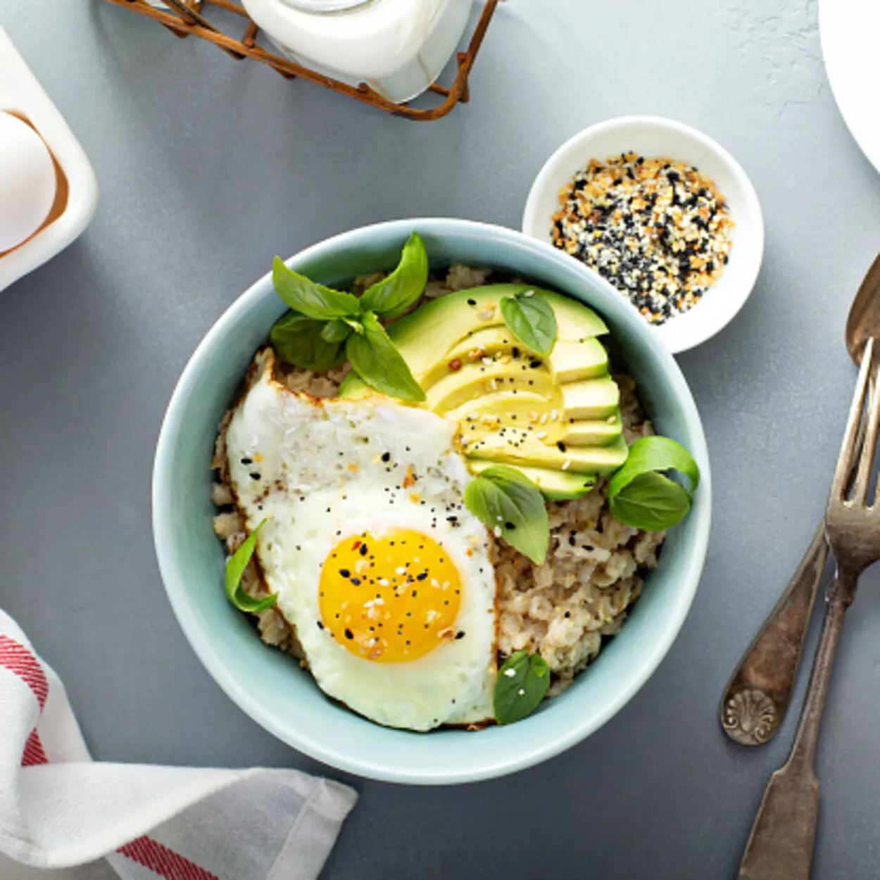 Oatmeal bowl with a half-fried egg and avocado on top