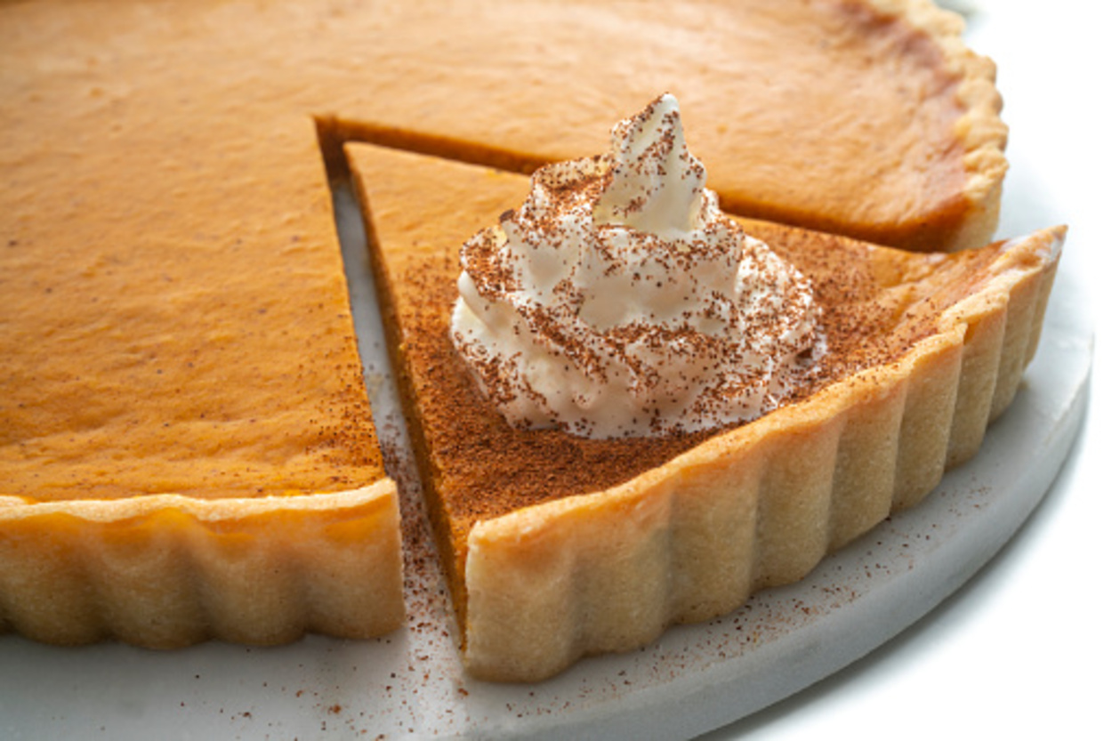 Pumpkin pie topped with cinnamon and cream.