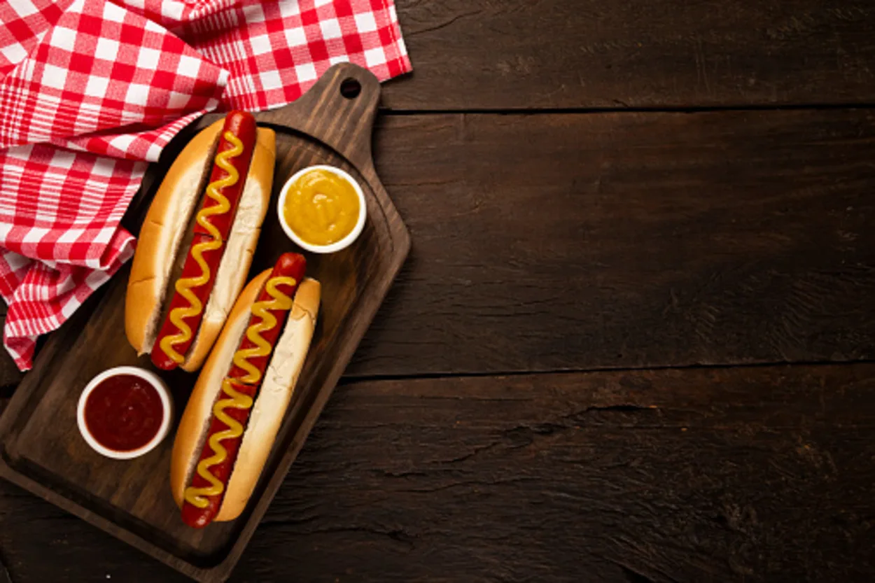 Hot dogs with buns and dipping sauce. 