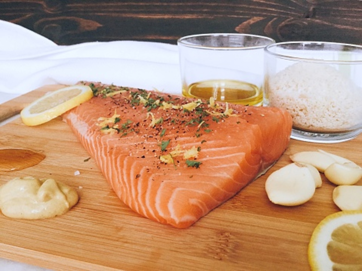 Salmon covered in spices on a wooden board