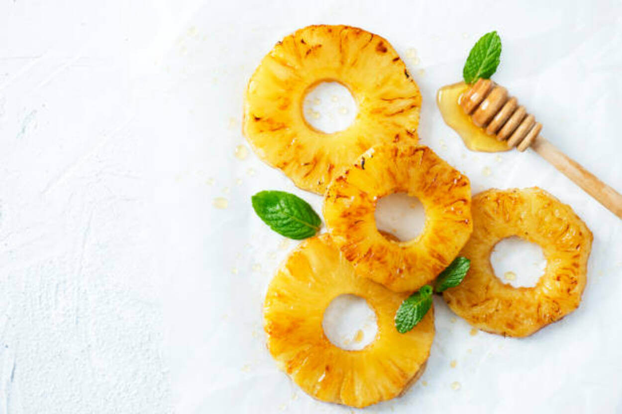 pineapple slices with some honey and mint leaves