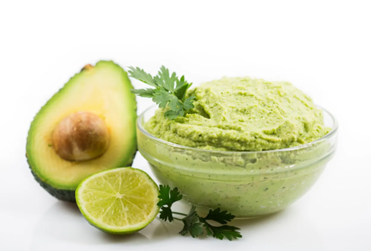 Avocado with lime and guacamole in a bowl