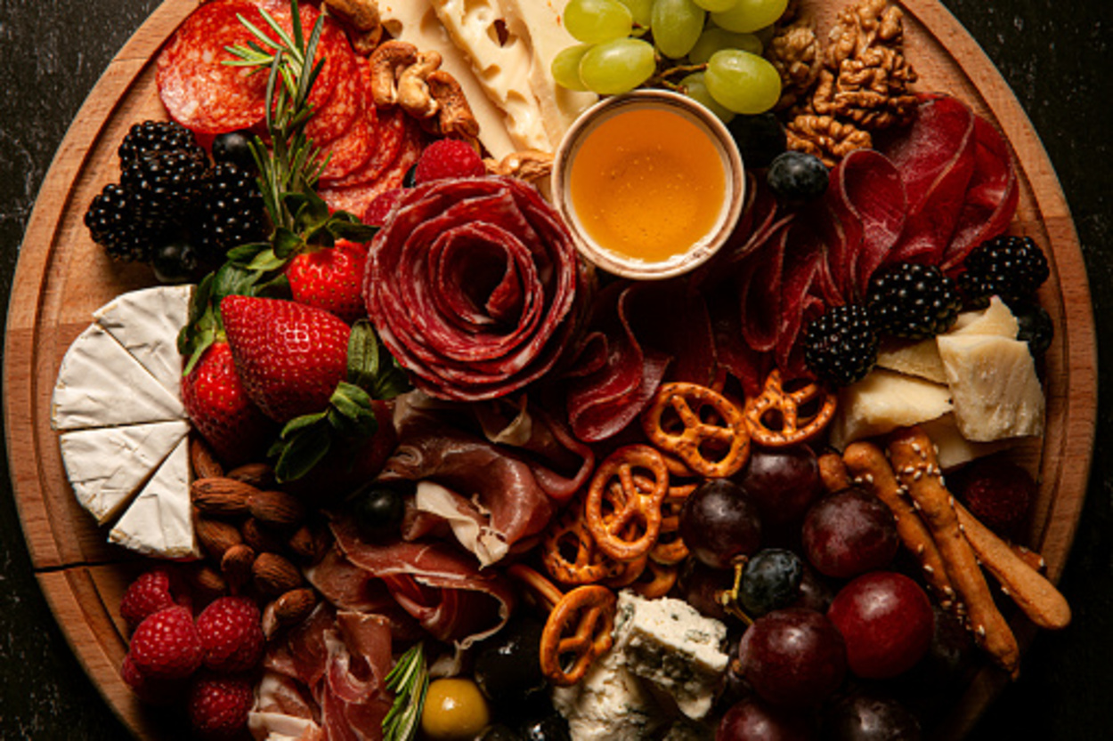 A charcuterie board full of fruits, nuts and snacks.