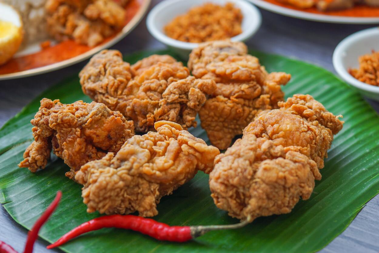 Air fried chicken pieces served on green leaf. 