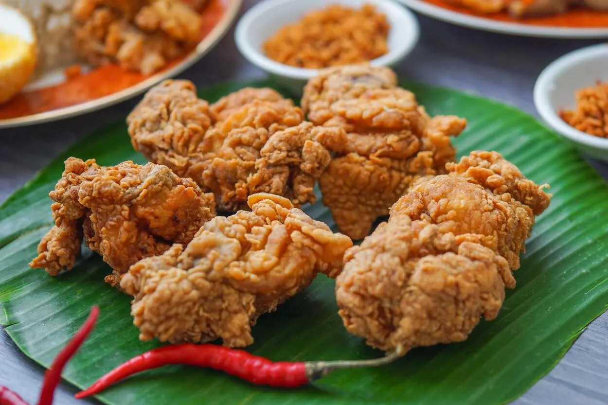 Air fried chicken pieces served on green leaf. 