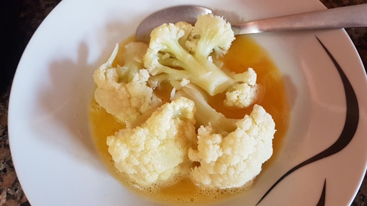 Cauliflower on a white plate dipped in egg