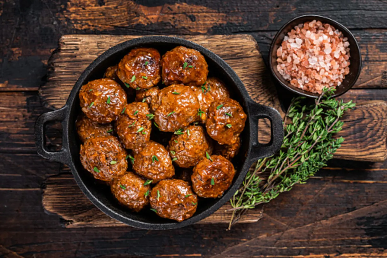 meatballs prepared in a pan with sauce by its side