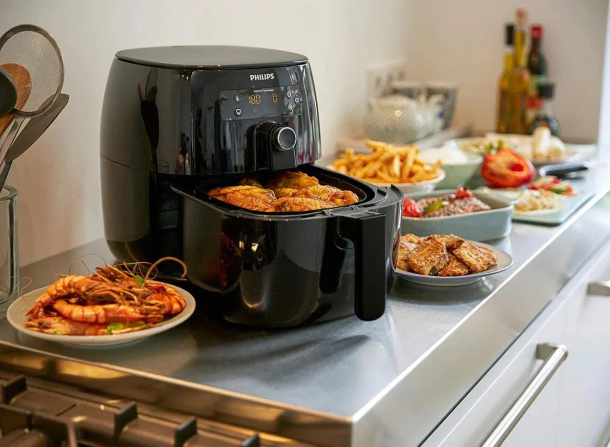 An air fryer with many dishes around
