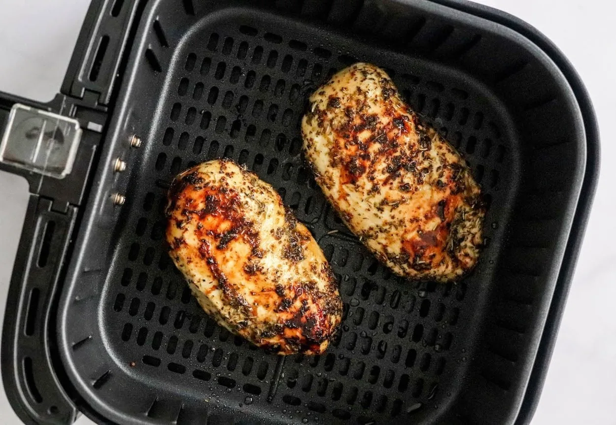 Cooked Chicken breast pieces in Air fryer basket. 