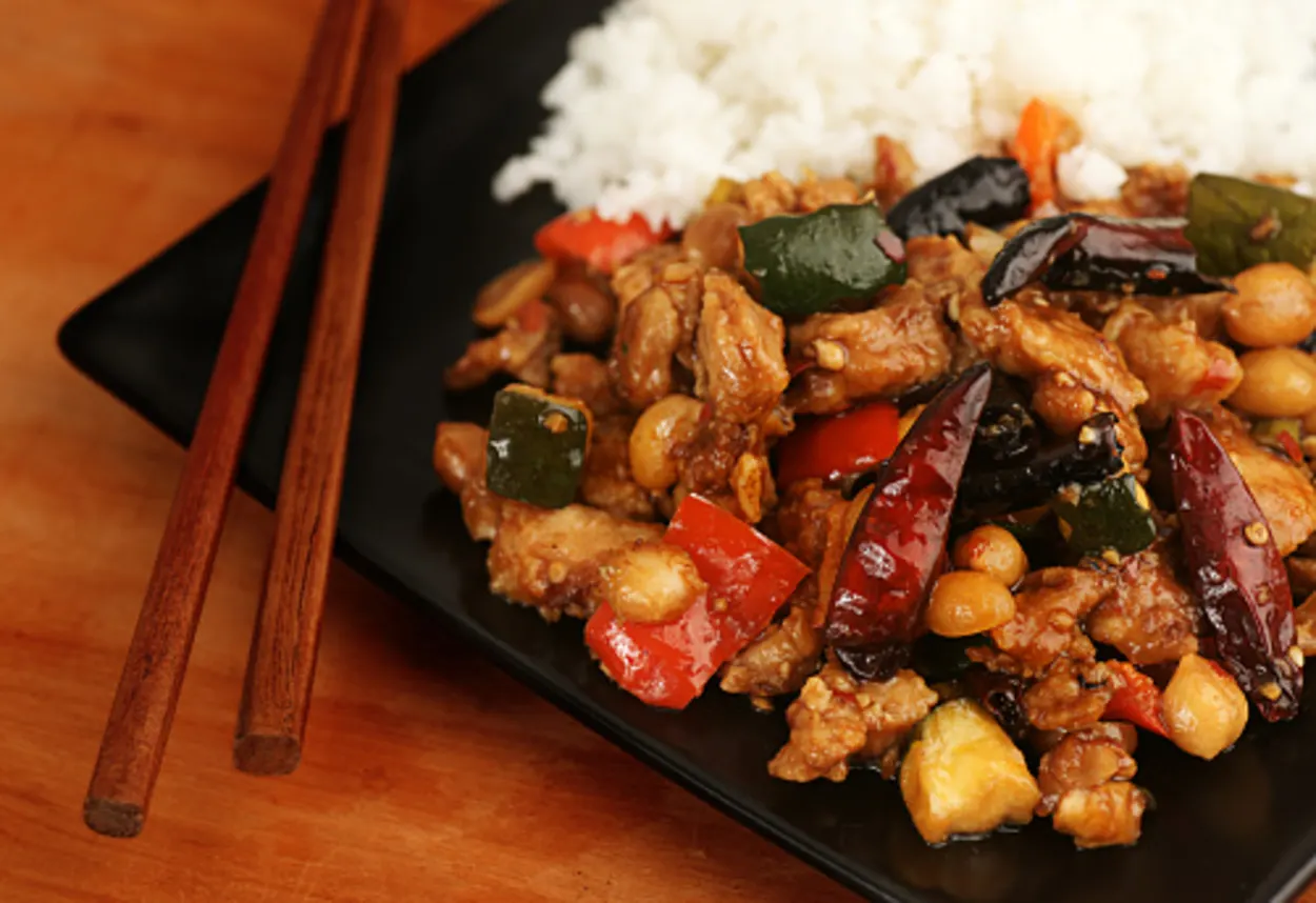 Kung Pao chicken and rice served with chopsticks