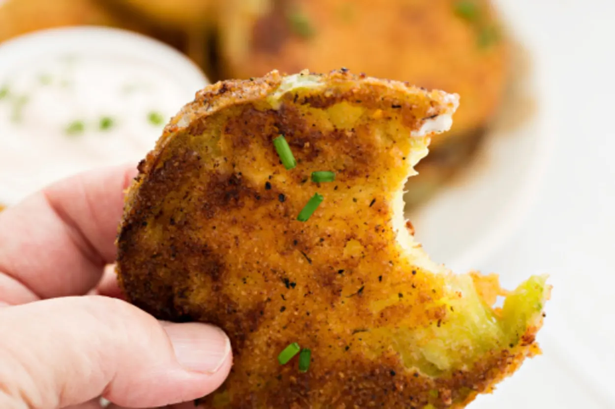 A person holding fried green tomato