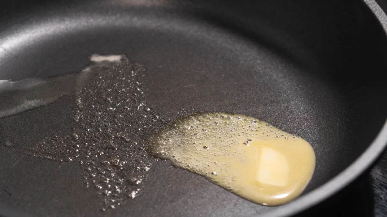 Butter melting on a hot nonstick surface of a metal.