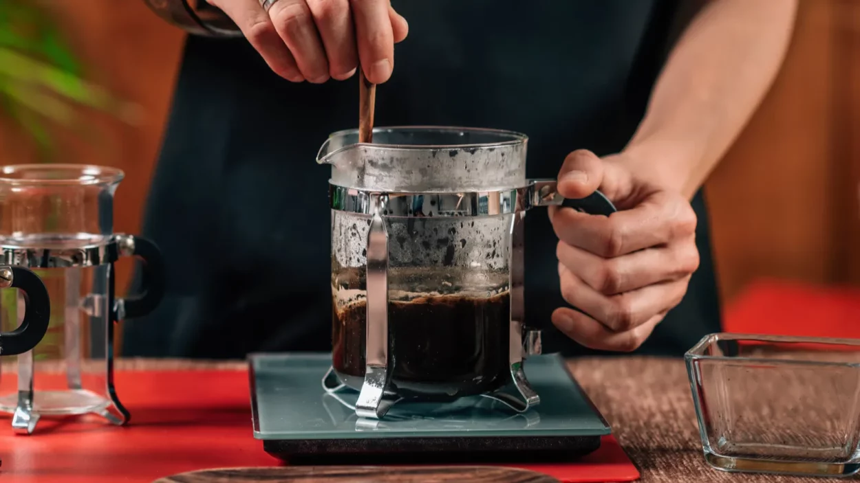 Human making french press coffee.