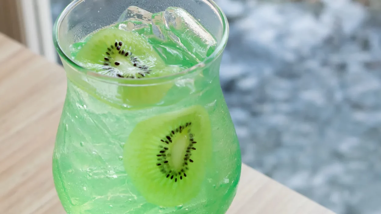 closeup glass of kiwi soda on wood table selective focus
