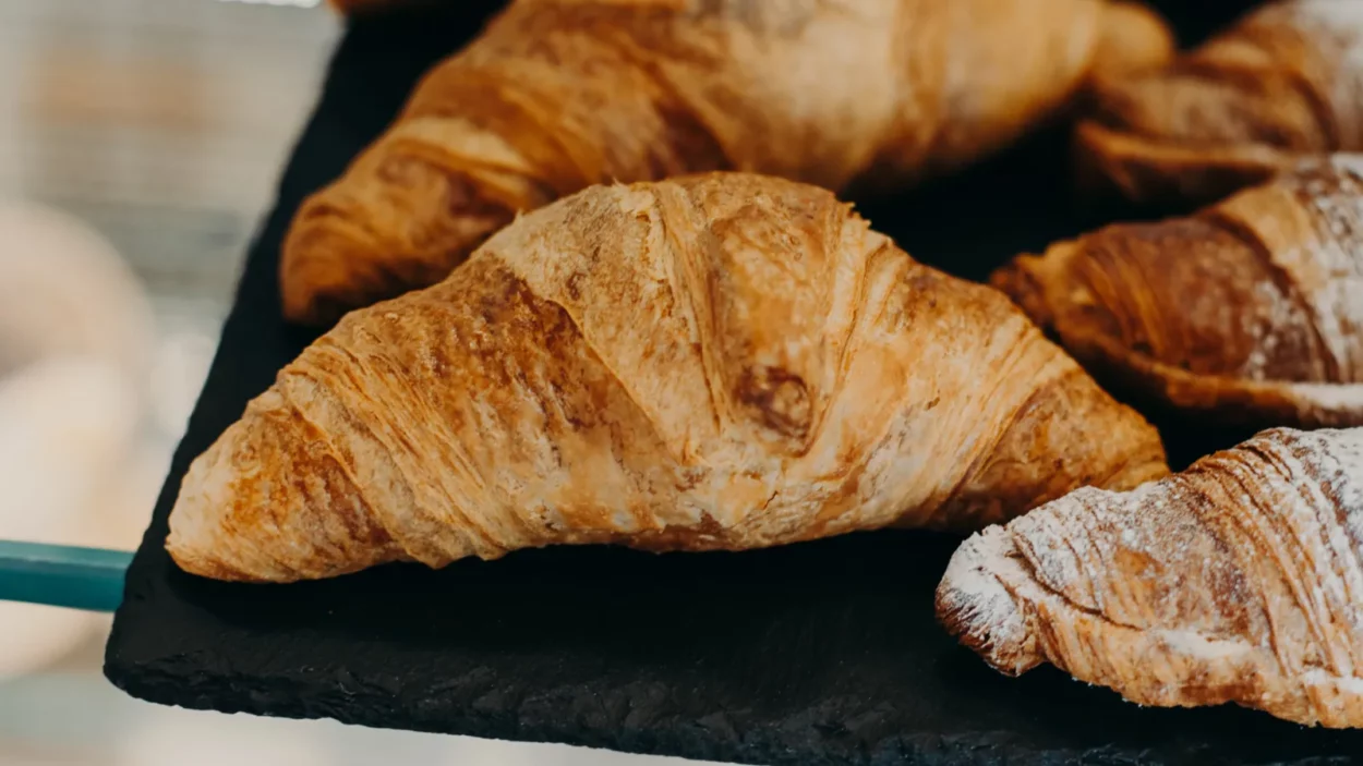 Freshly baked asiago croissants on towel.