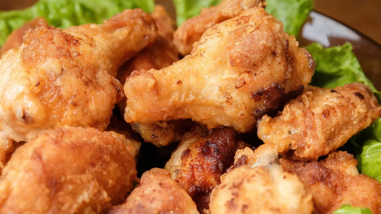 Fried chicken drumsticks on lettuce.