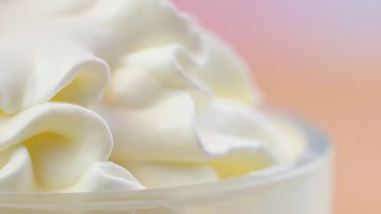 macro closeup of swirls of whipped cream for cake decorating