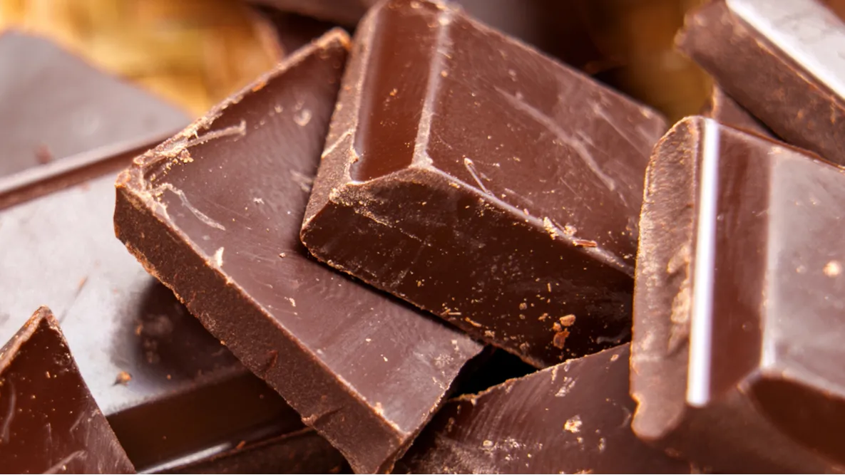 macro shot of dark bitter broken chocolate pieces in rustic
