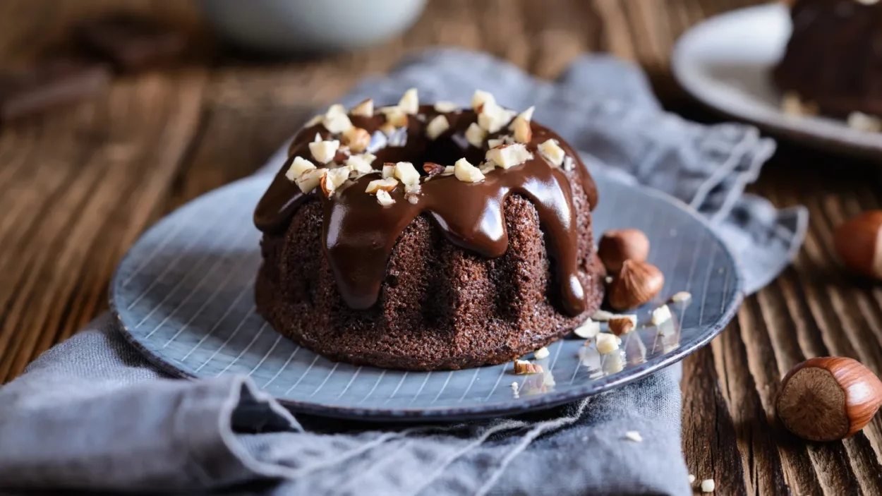 mini chocolate bundt cakes topped with glaze and chopped hazelnuts