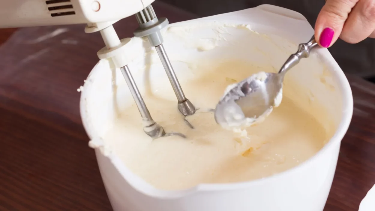 Whipping the cream with an electric mixer closeup.