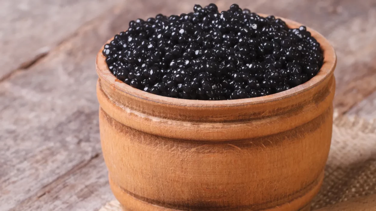 Black sturgeon caviar in a wooden a barrel on the table.