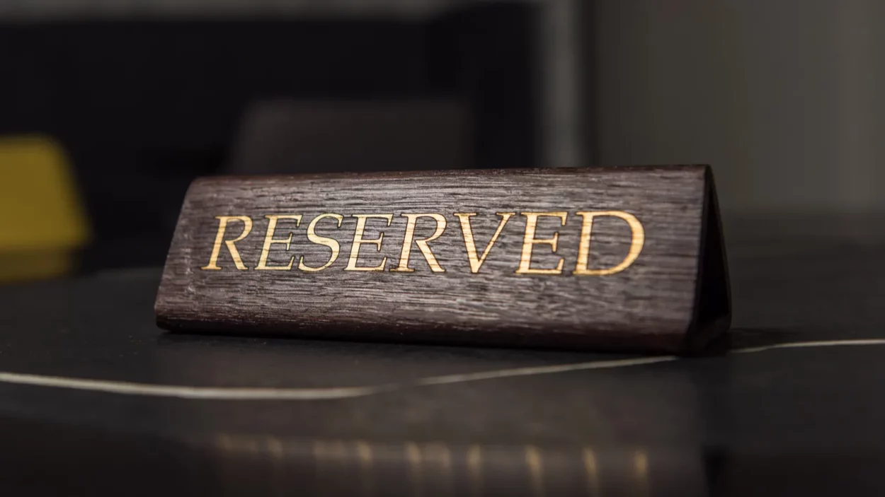 Selective focus of reserved sign on black table in cafe.