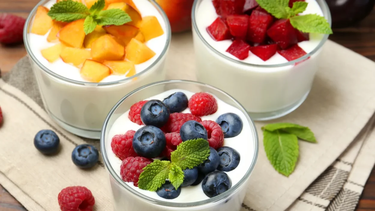 tasty yogurt with fresh berries fruits and mint in glasses