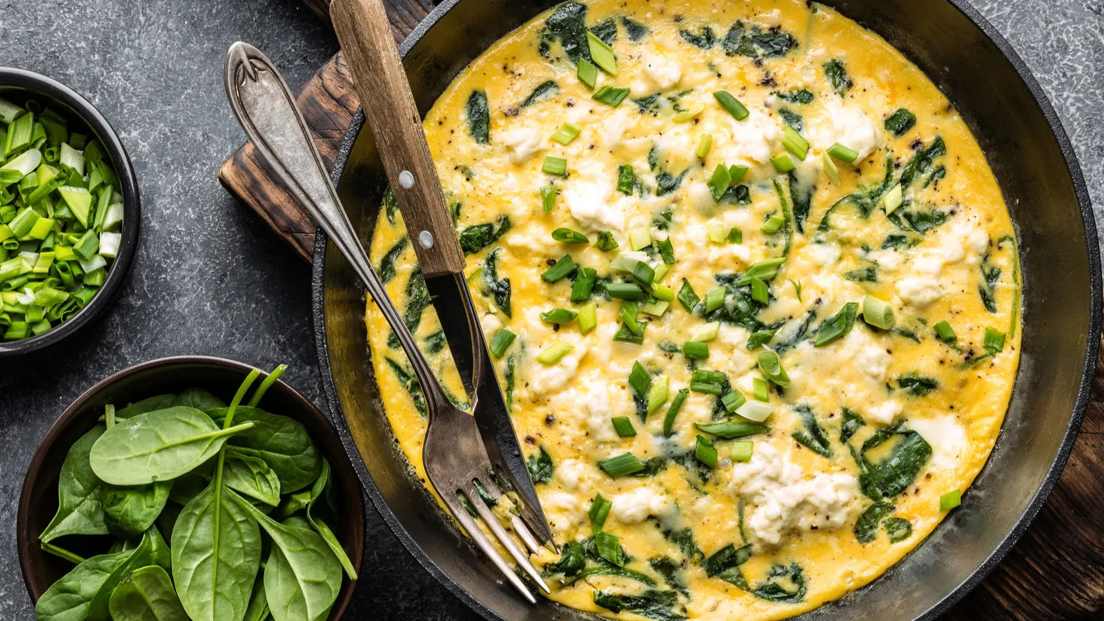 Omelette with spinach and cheese in a pan.