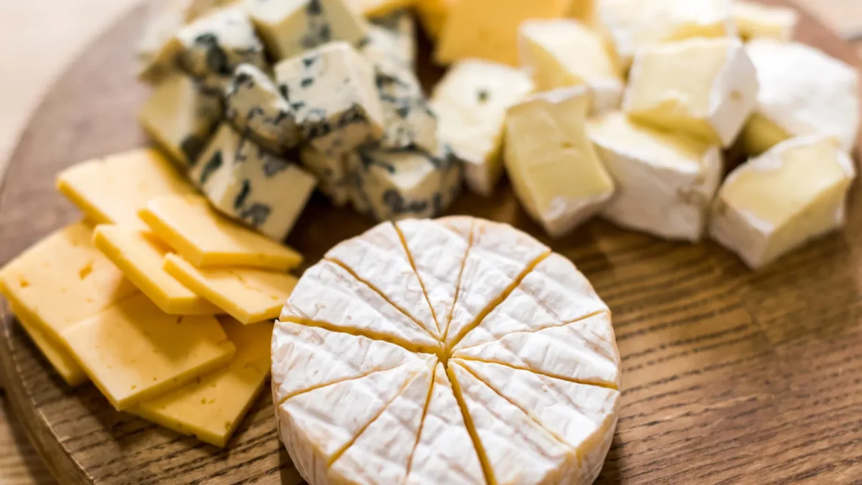 variety of cheese kinds on wooden board