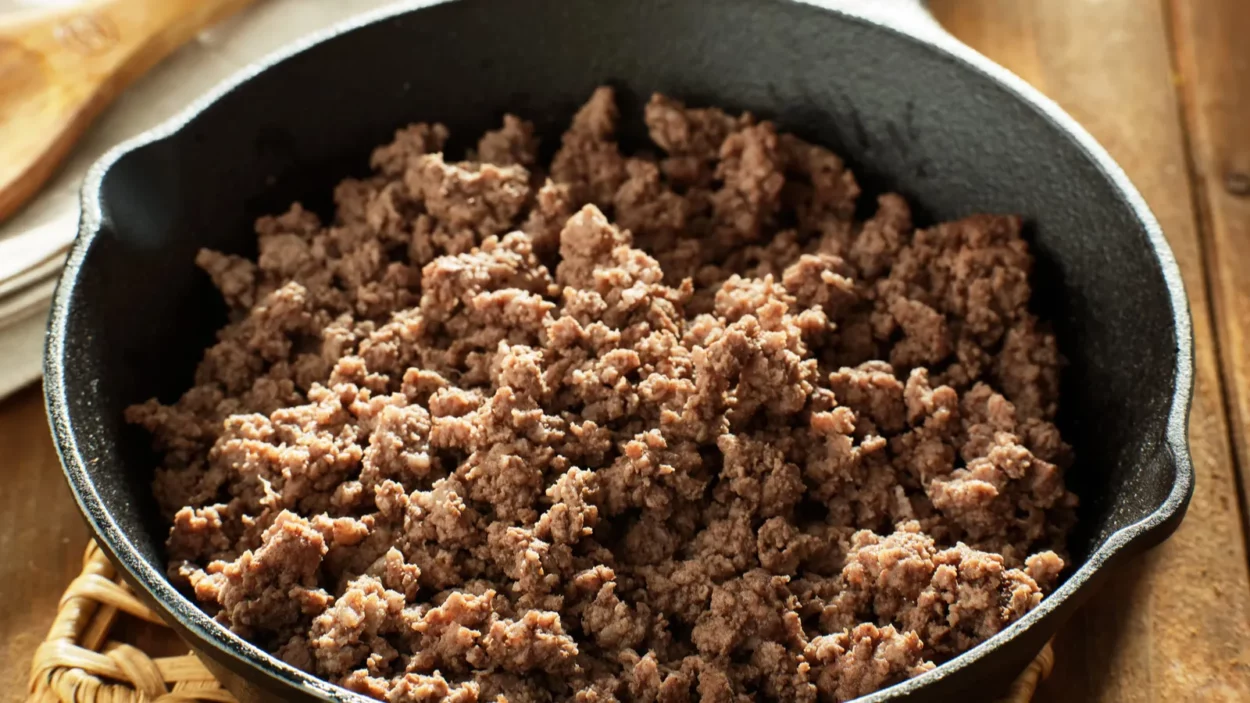 Browned ground beef in cast iron skillet.