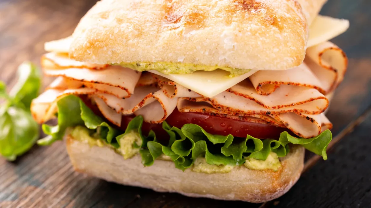 Fresh and healthy pesto turkey sandwich with white cheddar cheese.