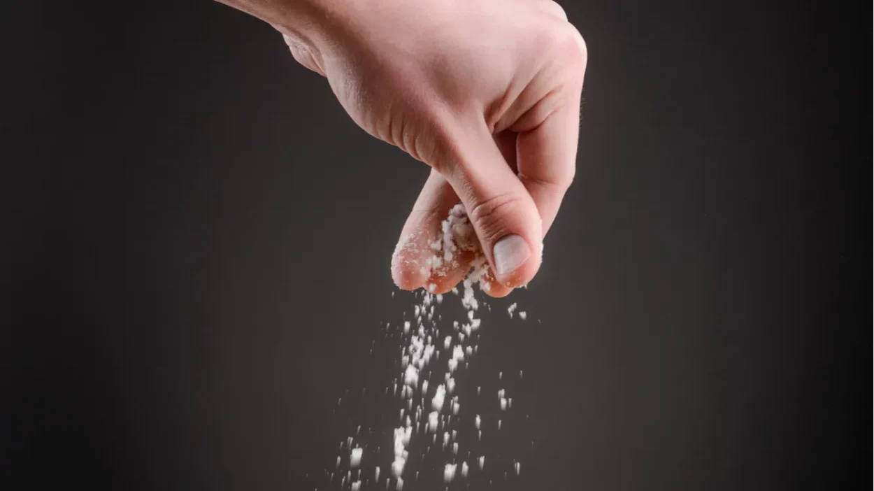 Sprinkling salt on a dish.