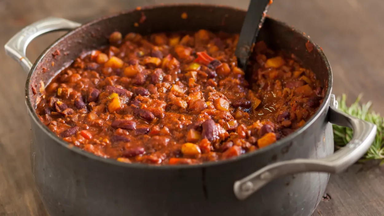 organic vegetarian chili in iron pot served with rosemary